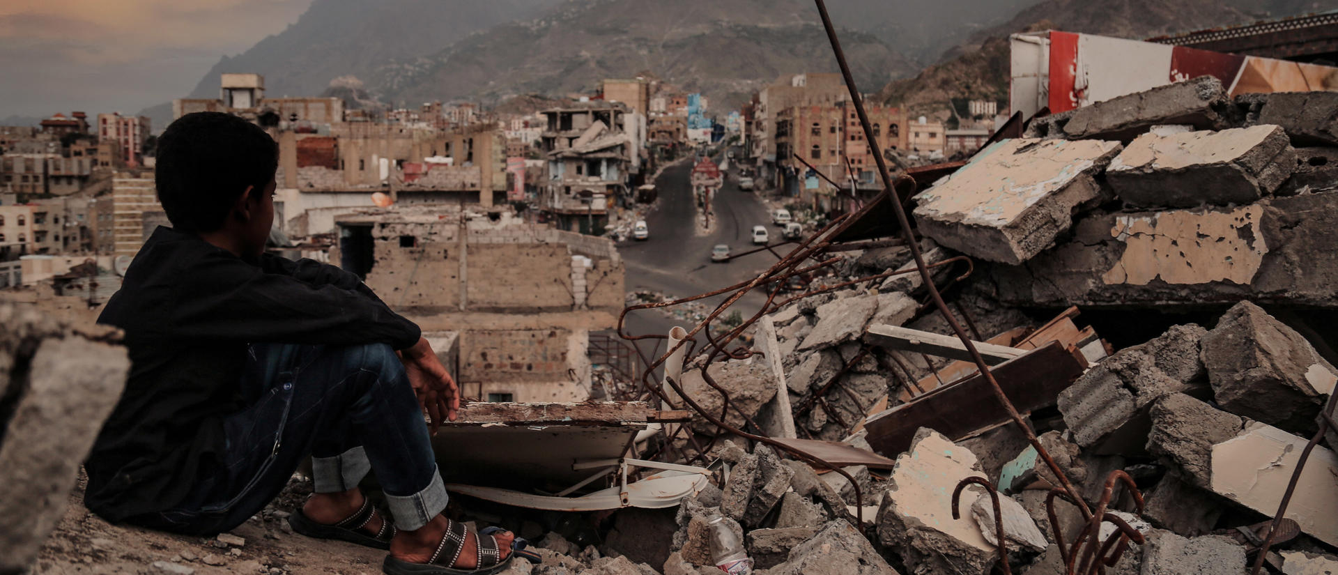 A child from Taiz City sits on the ruins of his ruined home because of the war on city-Yemen.